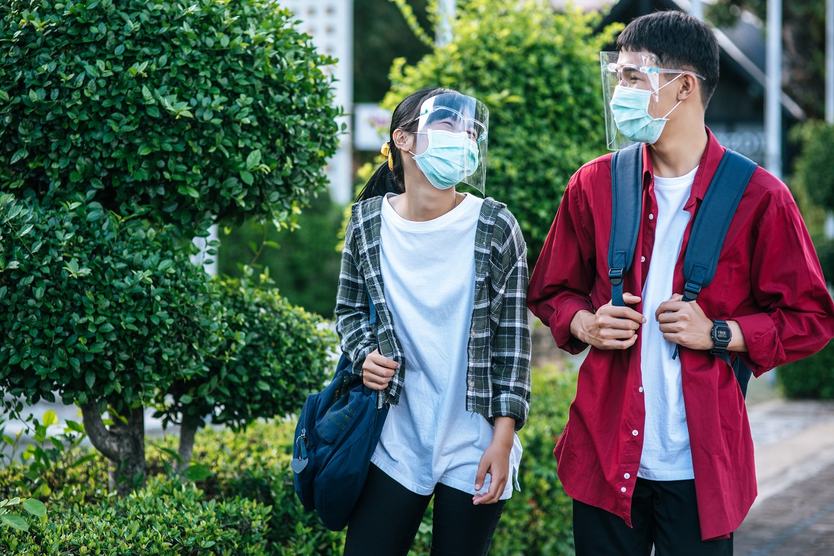 Male and female students wear face chill and masks Walk the foot